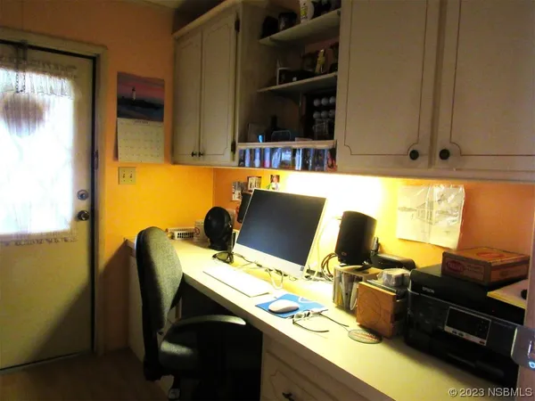 a view of a workspace with furniture and a window