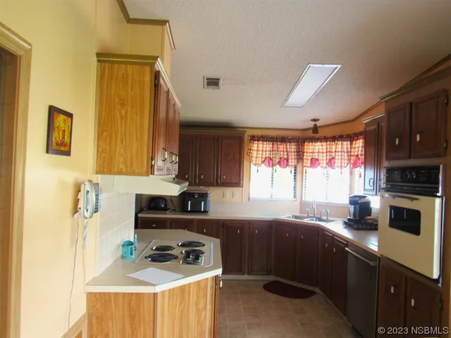 a kitchen with a sink a stove a microwave and cabinets