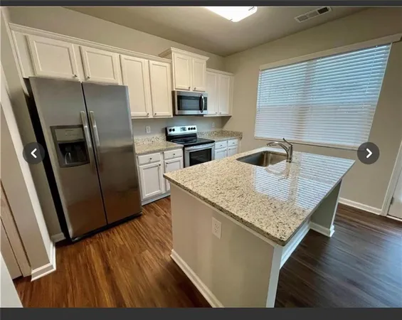 a kitchen with a refrigerator microwave and sink
