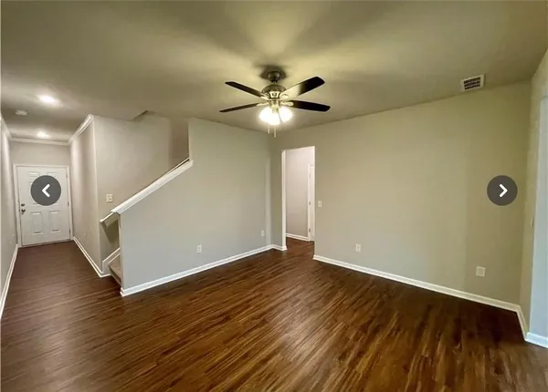 a view of an empty room with wooden floor