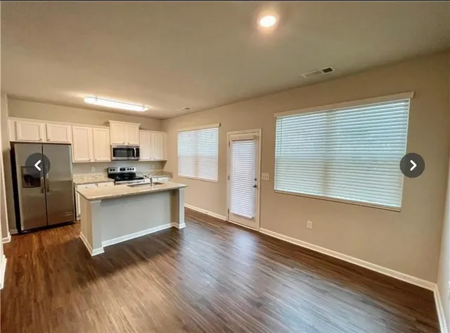 a kitchen with wooden floors and refrigerator