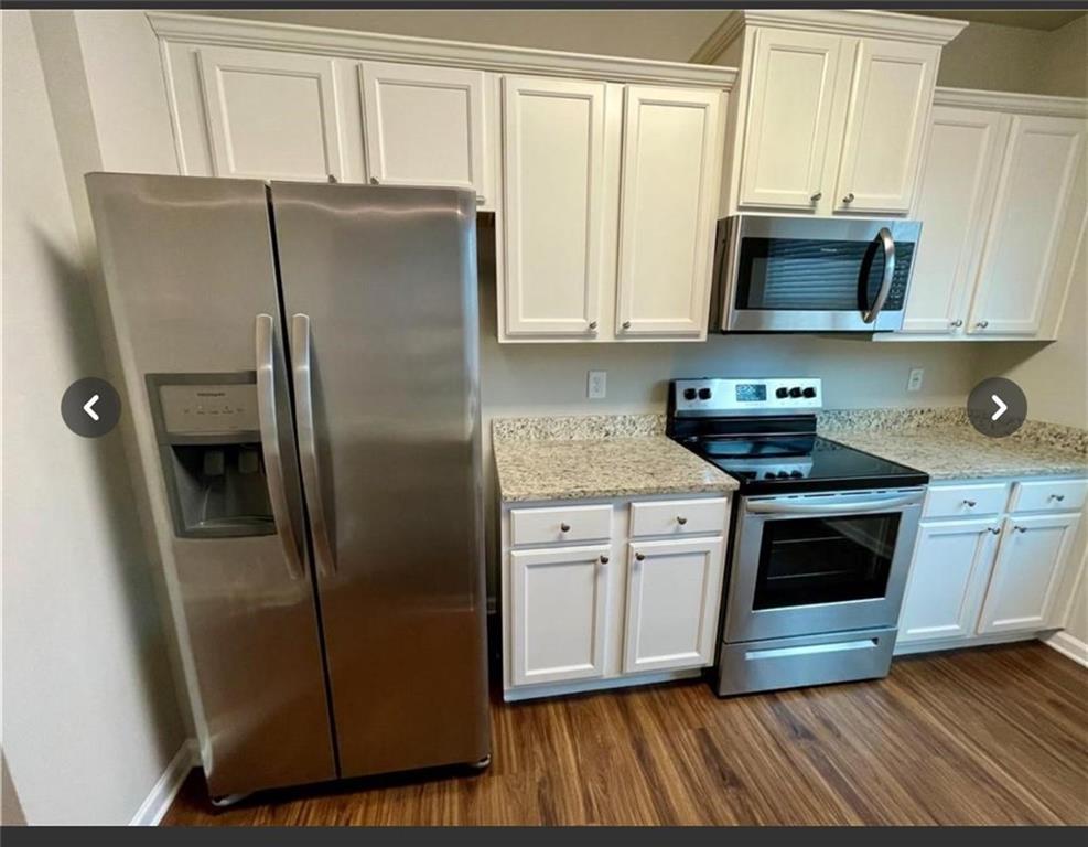 219 Turner Lane Woodstock, GA 30188 - Photo 8 of 15 a kitchen with stainless steel appliances granite countertop a refrigerator a stove a sink and a microwave