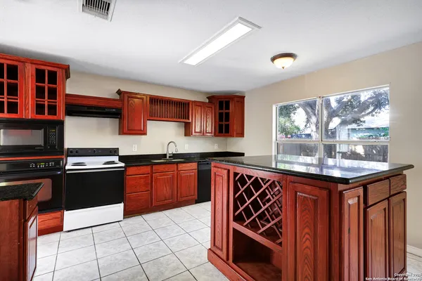 a view of an empty room with window and hardwood floor