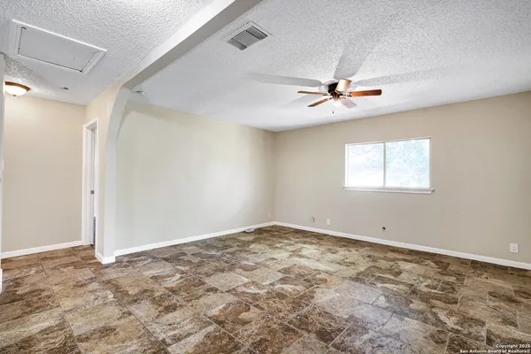 an empty room with a window and a ceiling fan