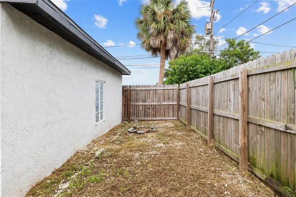 a backyard of a house with a barbeque and wooden fence