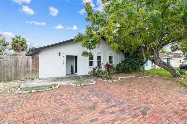 a view of a house with a tree in front of it