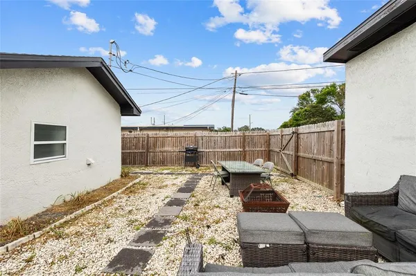 a roof deck with table and chairs and potted plants