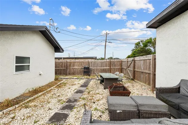 a roof deck with table and chairs and potted plants