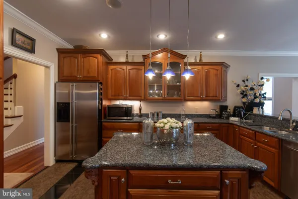 a kitchen with stainless steel appliances granite countertop a stove top oven a sink dishwasher and cabinets with wooden floor