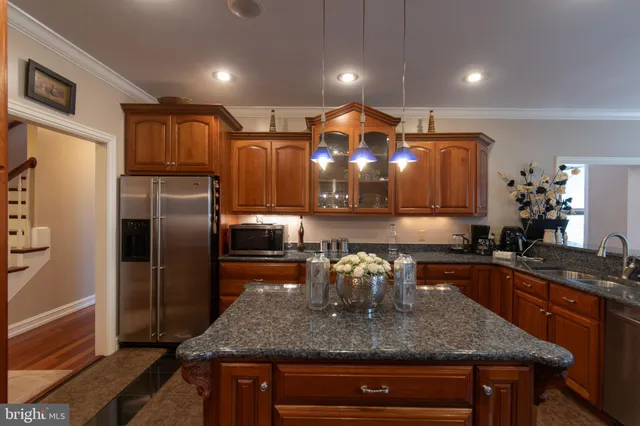 a kitchen with stainless steel appliances granite countertop a stove top oven a sink dishwasher and cabinets with wooden floor