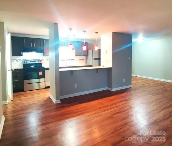 a kitchen with stainless steel appliances wooden floor and top oven