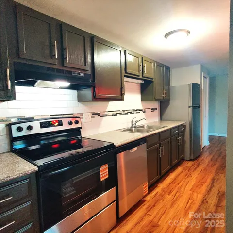a kitchen with stainless steel appliances wooden cabinets and a stove top oven