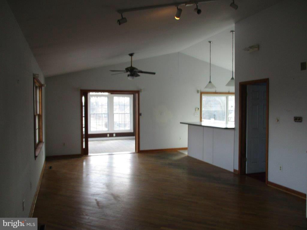 3223 Lynch Road Baltimore, MD 21219 - Photo 2 of 15 an empty room with wooden floor cabinet and windows