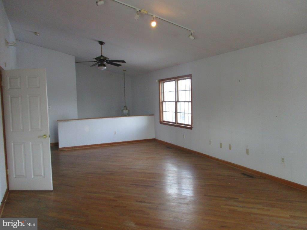 3223 Lynch Road Baltimore, MD 21219 - Photo 3 of 15 wooden floor in an empty room with a window