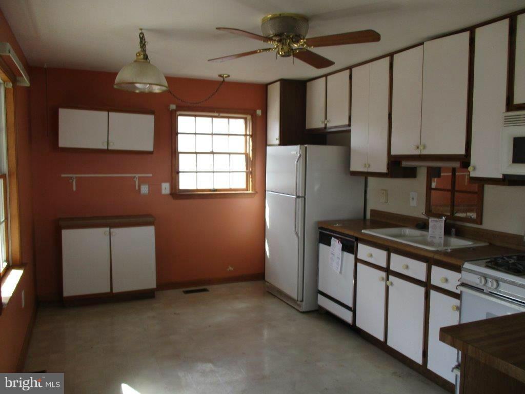 3223 Lynch Road Baltimore, MD 21219 - Photo 8 of 15 a kitchen with stainless steel appliances granite countertop a refrigerator a sink and white cabinets