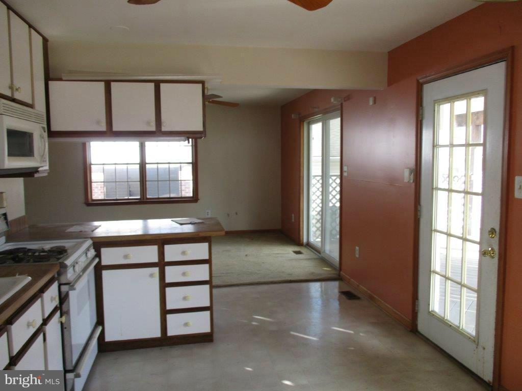 3223 Lynch Road Baltimore, MD 21219 - Photo 9 of 15 a view of an empty room with window and stairs