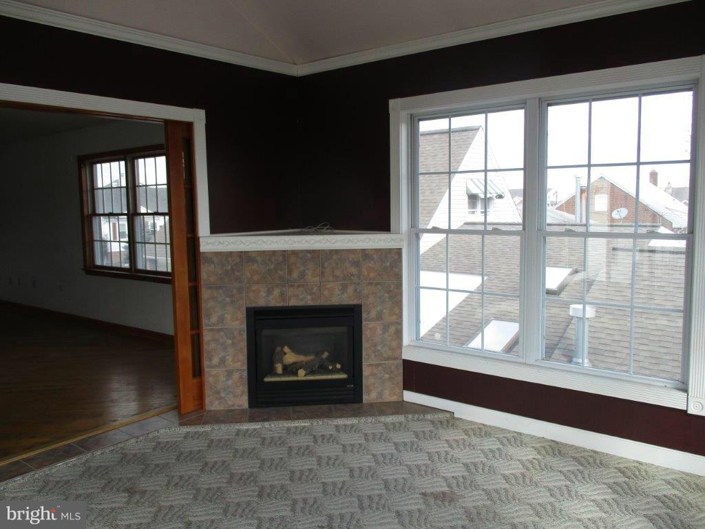 3223 Lynch Road Baltimore, MD 21219 - Photo 10 of 15 a living room with a fireplace with a floor to ceiling window