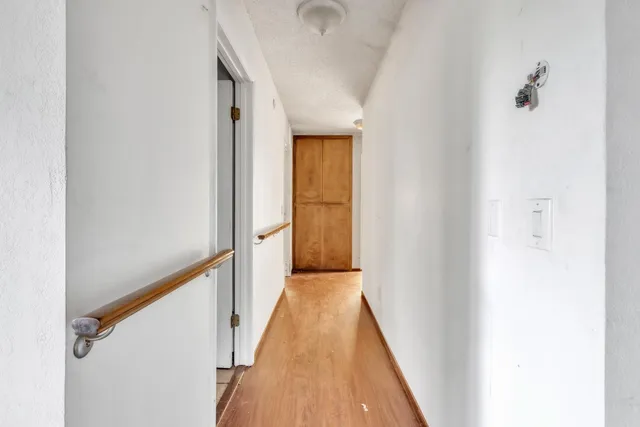 a view of a hallway with wooden floor