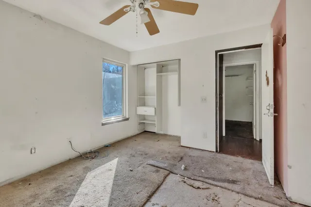 an empty room with windows and closet