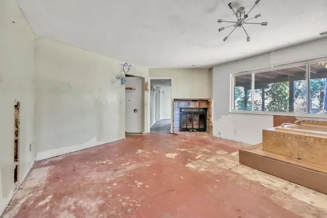 a view of an empty room with a fireplace and a window