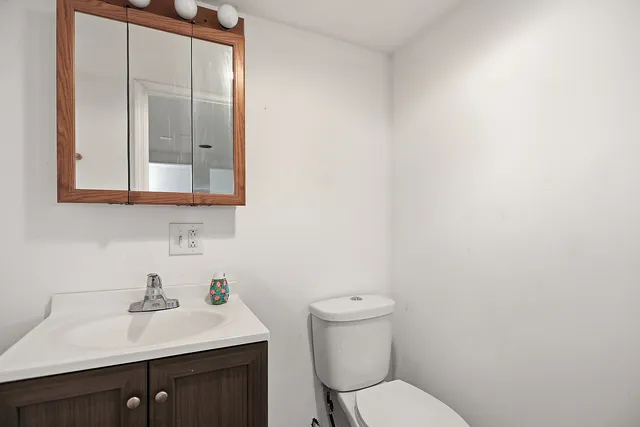 a bathroom with a toilet a sink and mirror