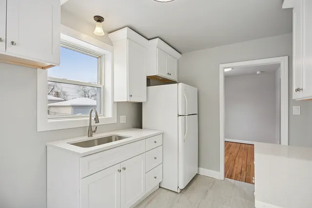 a kitchen with a refrigerator sink and cabinets