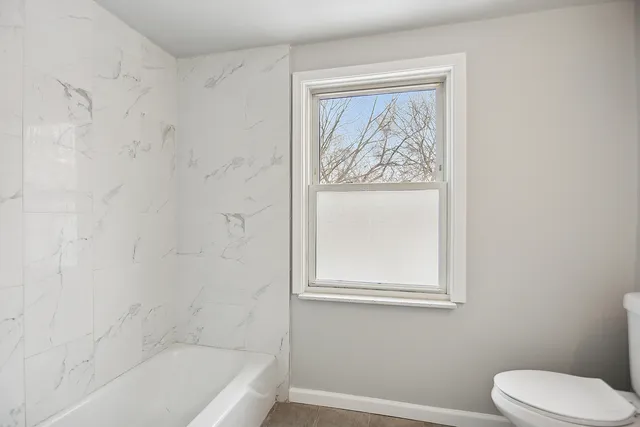 a bathroom with a toilet and a bathtub