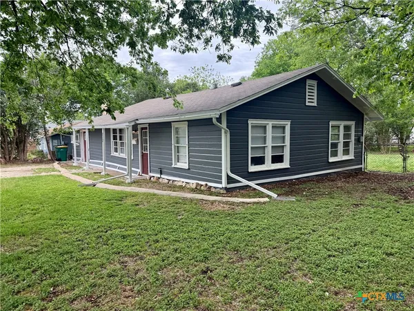 a backyard of a house with yard table and chairs