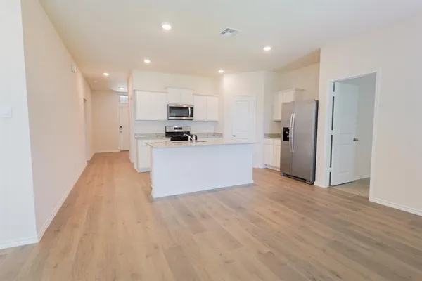 a view of a kitchen with wooden floor and electronic appliances