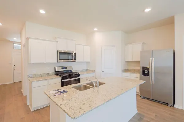 a kitchen with a refrigerator a stove top oven a sink and dishwasher
