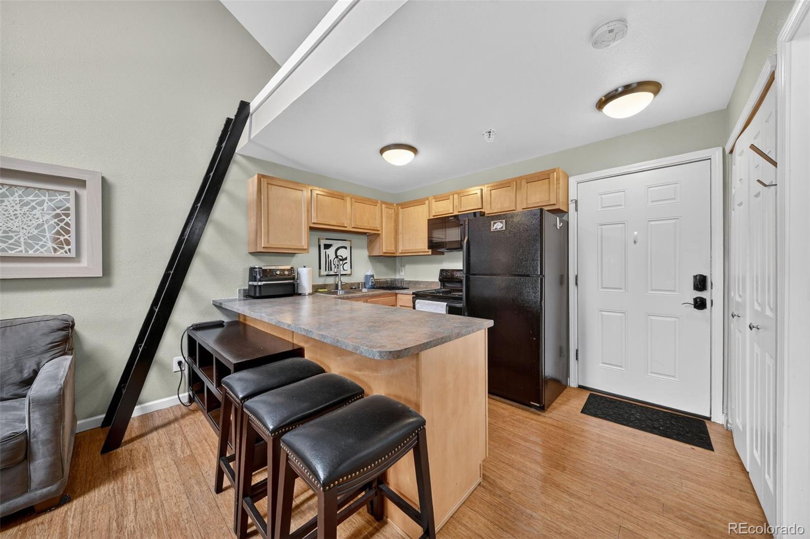 1405 Broadway, Unit 307 Boulder, CO 80302 - Photo 14 of 20 a kitchen with stainless steel appliances granite countertop a refrigerator a stove a sink dishwasher a dining table and chairs with wooden floor