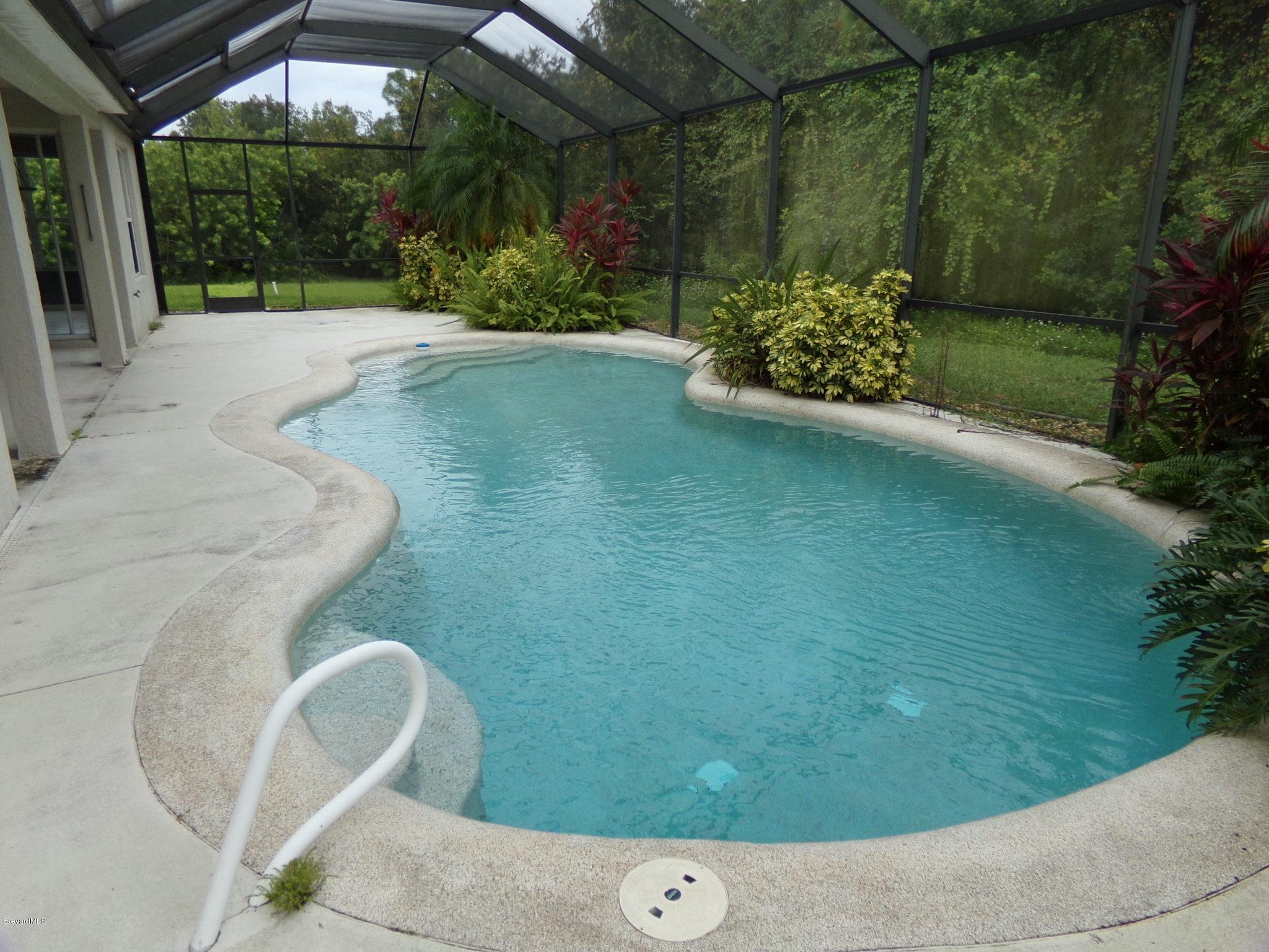 3995 Harlock Road Melbourne, FL 32934 - Photo 13 of 34 a view of backyard with trampoline
