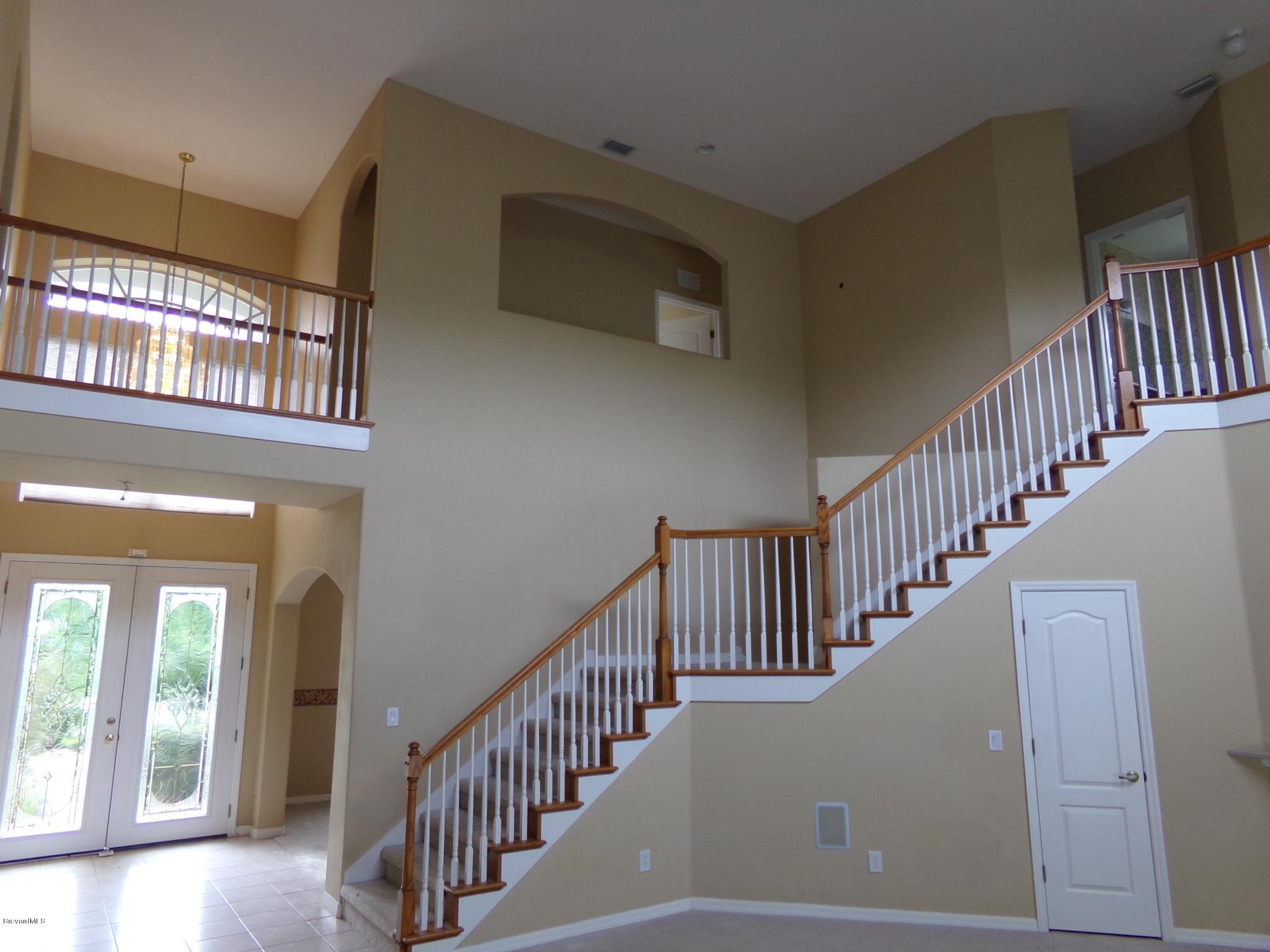 3995 Harlock Road Melbourne, FL 32934 - Photo 15 of 34 a view of staircase with black white wall and a chandelier