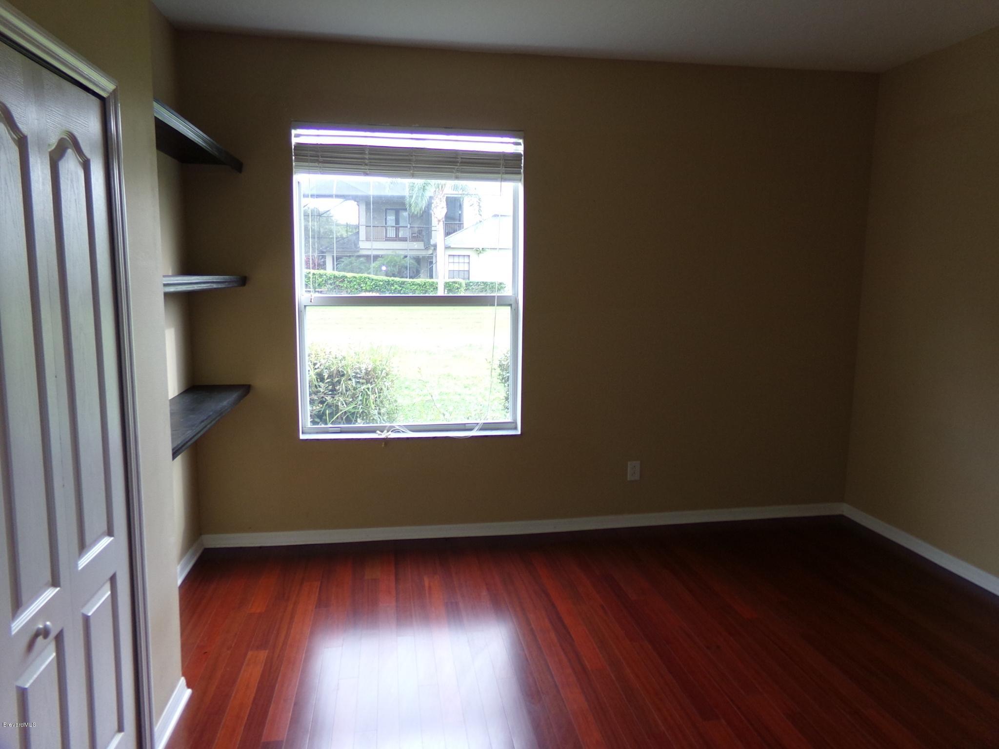 3995 Harlock Road Melbourne, FL 32934 - Photo 21 of 34 an empty room with wooden floor and windows