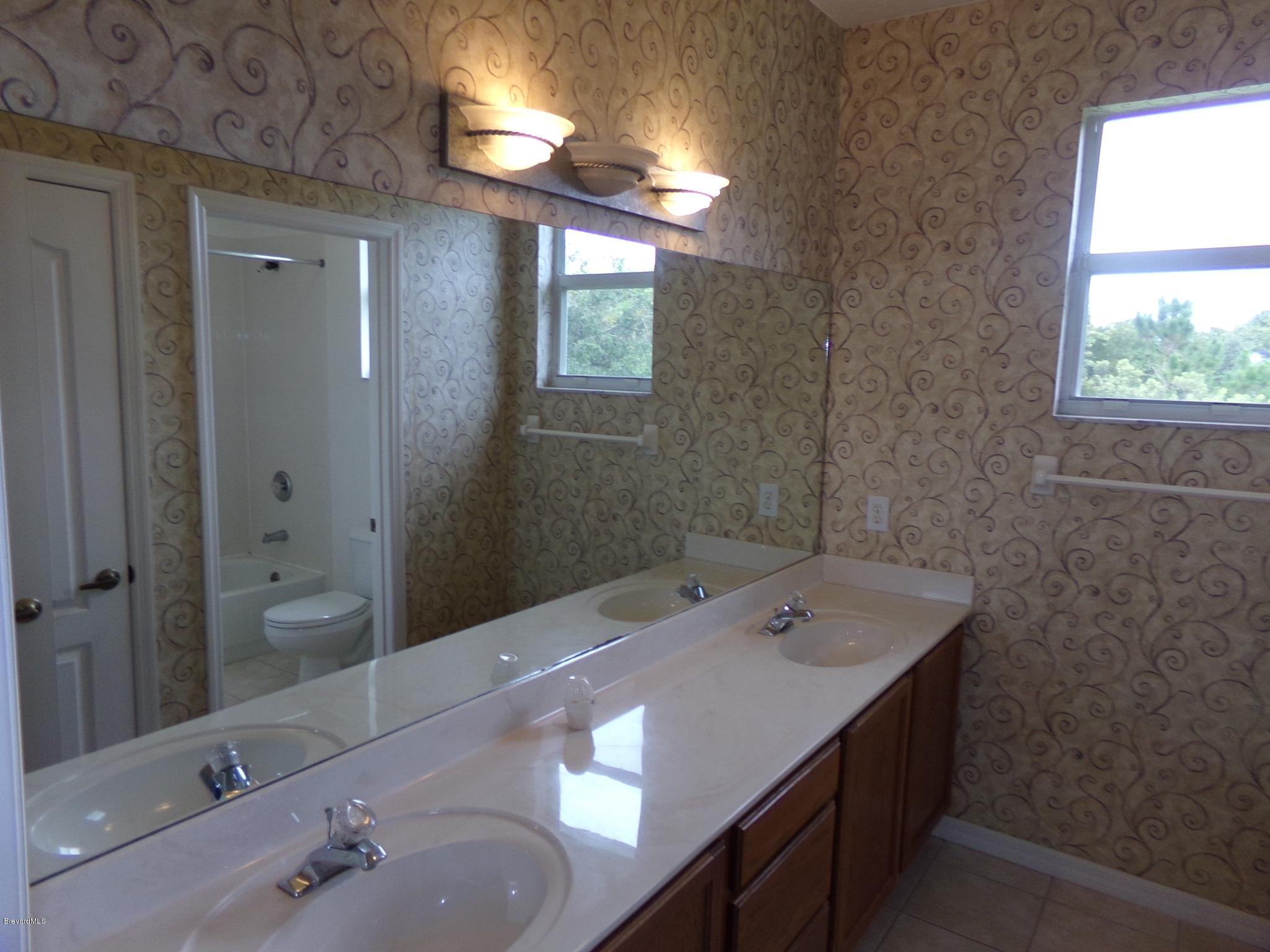 3995 Harlock Road Melbourne, FL 32934 - Photo 31 of 34 a bathroom with a sink a toilet and shower