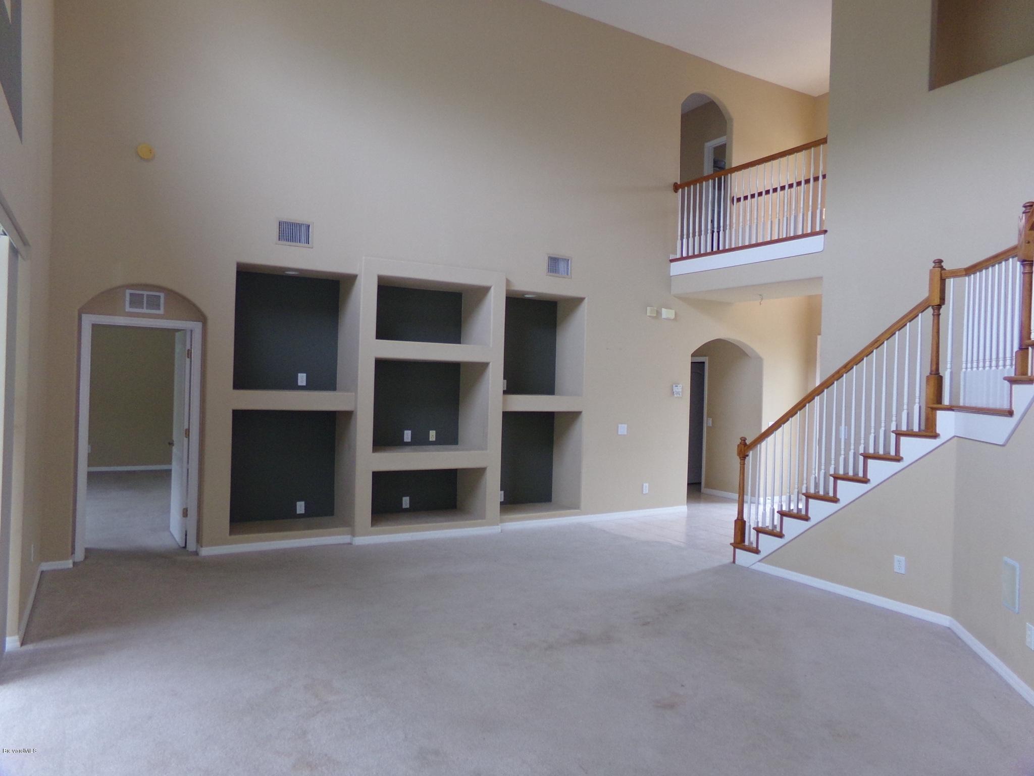 3995 Harlock Road Melbourne, FL 32934 - Photo 9 of 34 a view of an empty room with fireplace and stairs