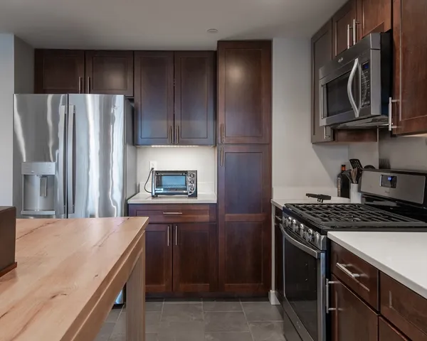 a kitchen with stainless steel appliances granite countertop a refrigerator stove and sink