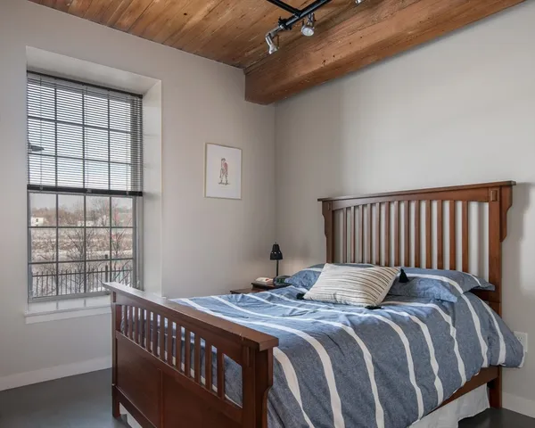 a bedroom with a bed and a window