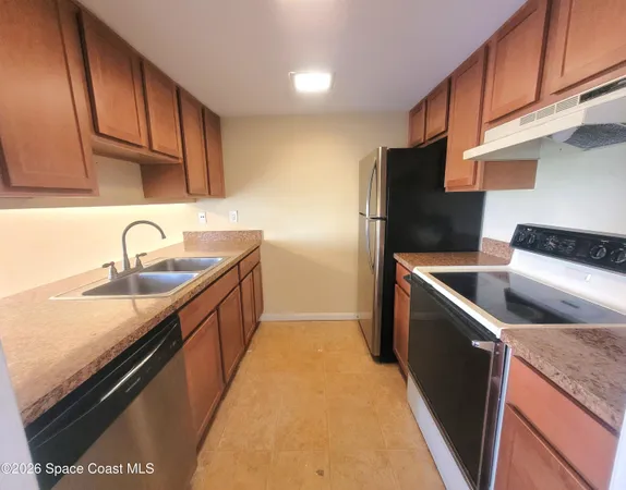 a kitchen with a sink a refrigerator and cabinets