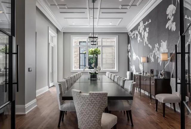 a view of a dining room with furniture a chandelier and large windows