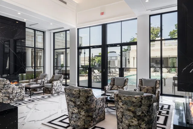 a living room with furniture large windows and wooden floor