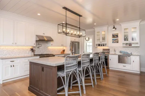 a kitchen with stainless steel appliances a stove a table and chairs in it