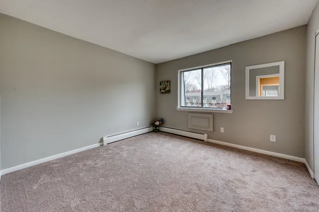 an empty room with mirror and a bench