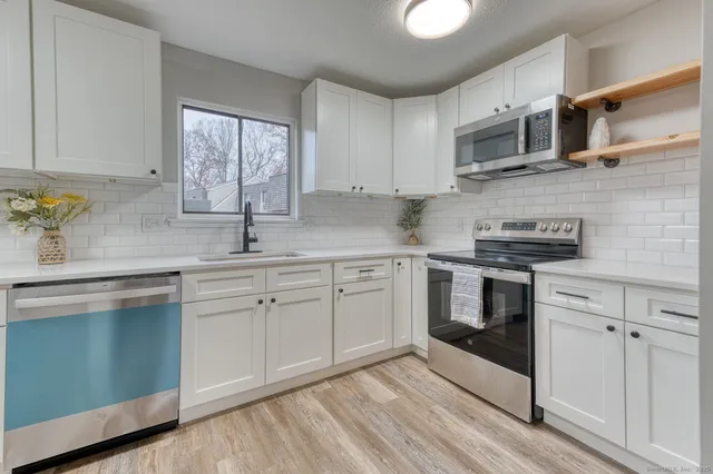 a kitchen with cabinets appliances and a window