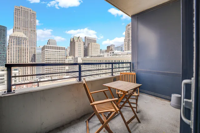 a view of a city from a balcony with furniture