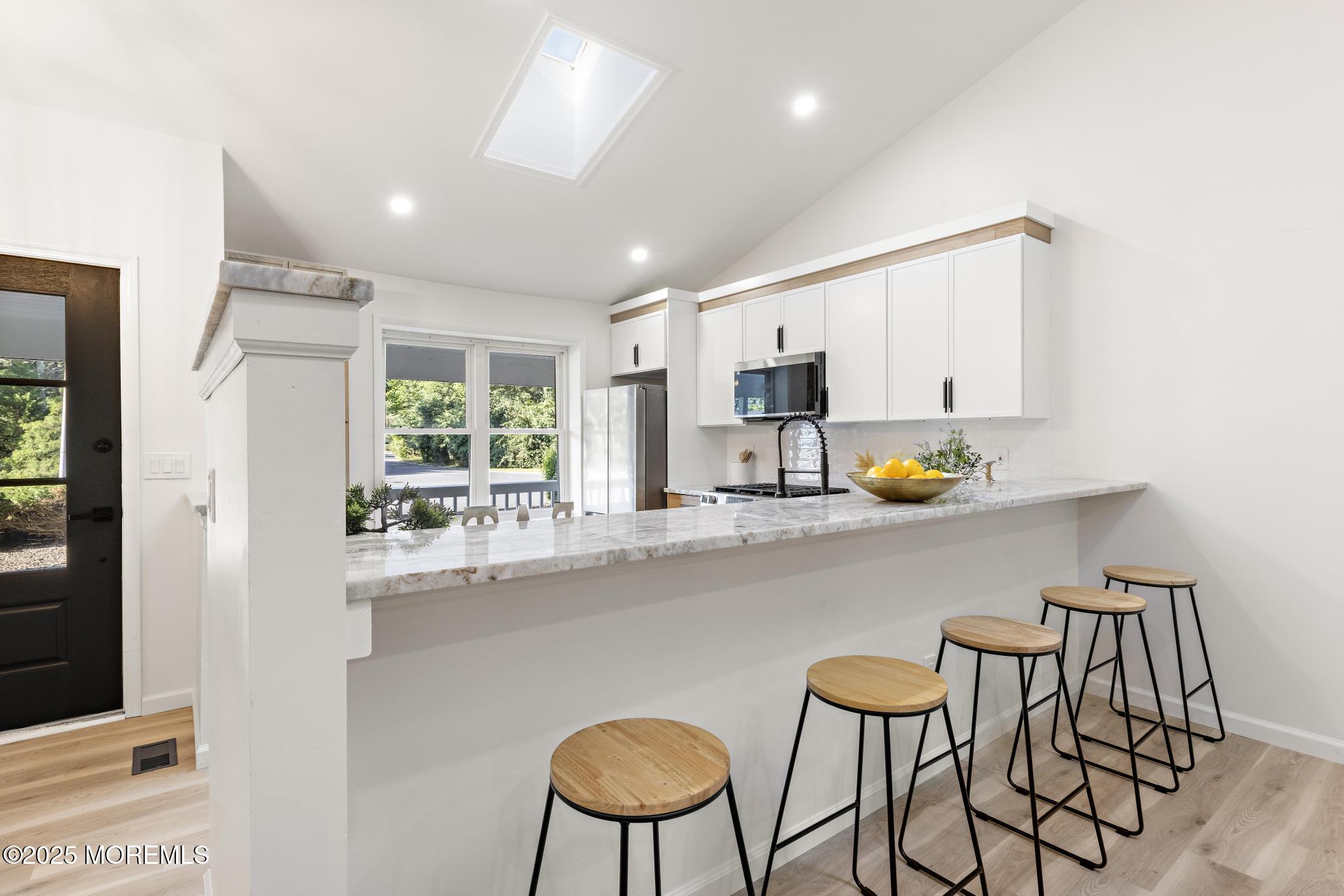 247 Jennings Road Manahawkin, NJ 08050 - Photo 11 of 35 a kitchen with stainless steel appliances a dining table chairs and a refrigerator