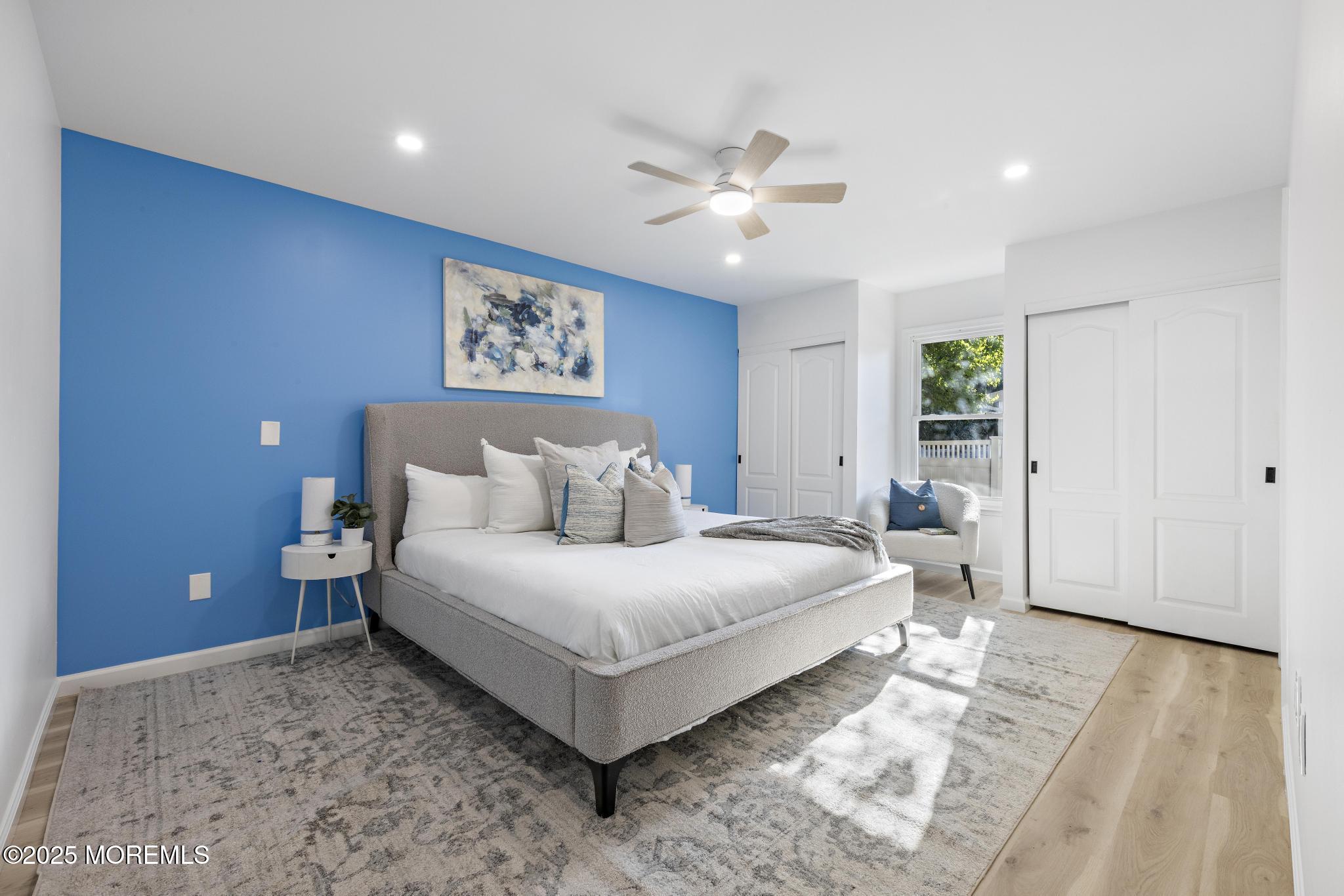 247 Jennings Road Manahawkin, NJ 08050 - Photo 23 of 35 a spacious bedroom with a large bed and a chandelier