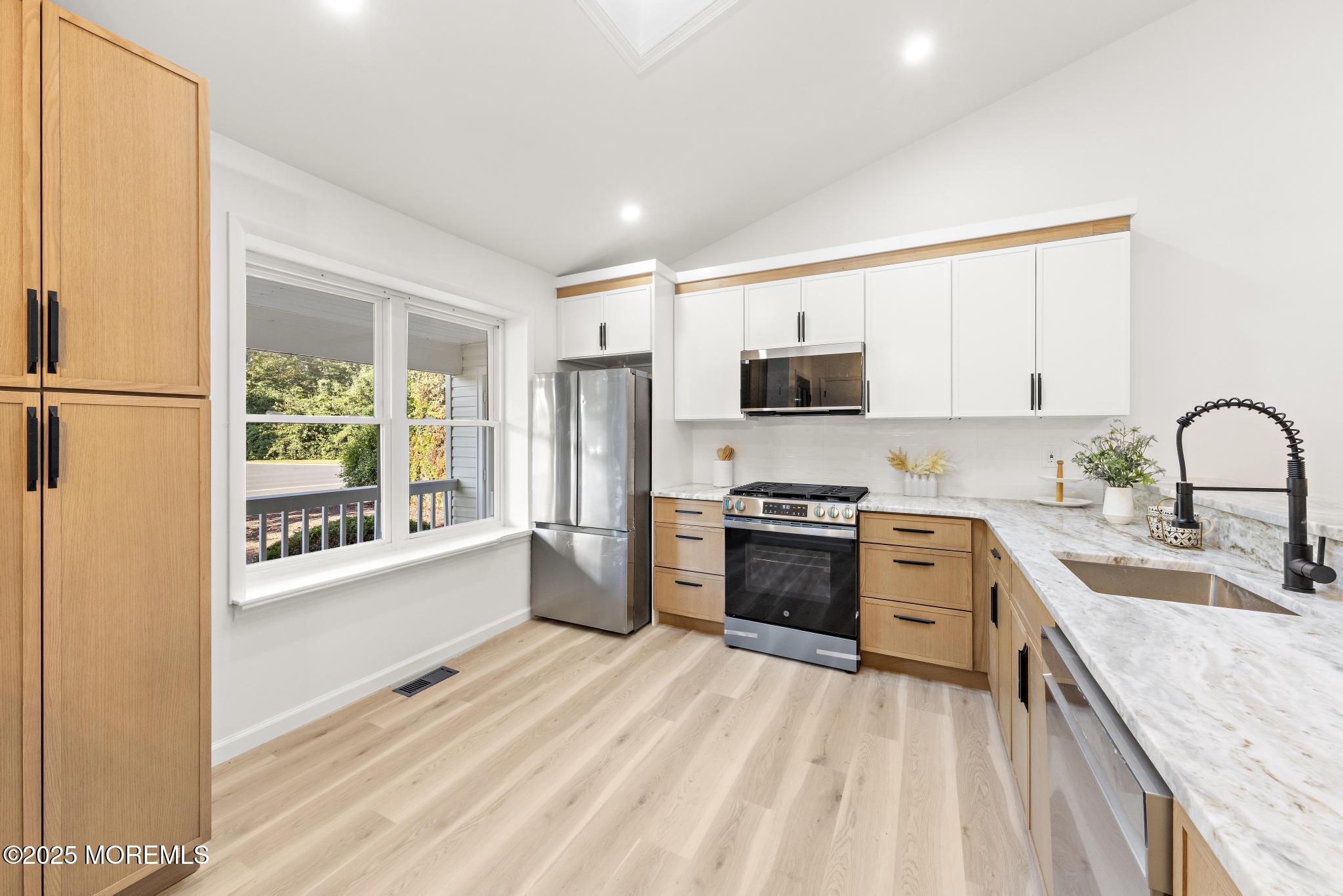 247 Jennings Road Manahawkin, NJ 08050 - Photo 7 of 35 a large kitchen with kitchen island granite countertop a stove a sink a refrigerator with a dining table and chairs