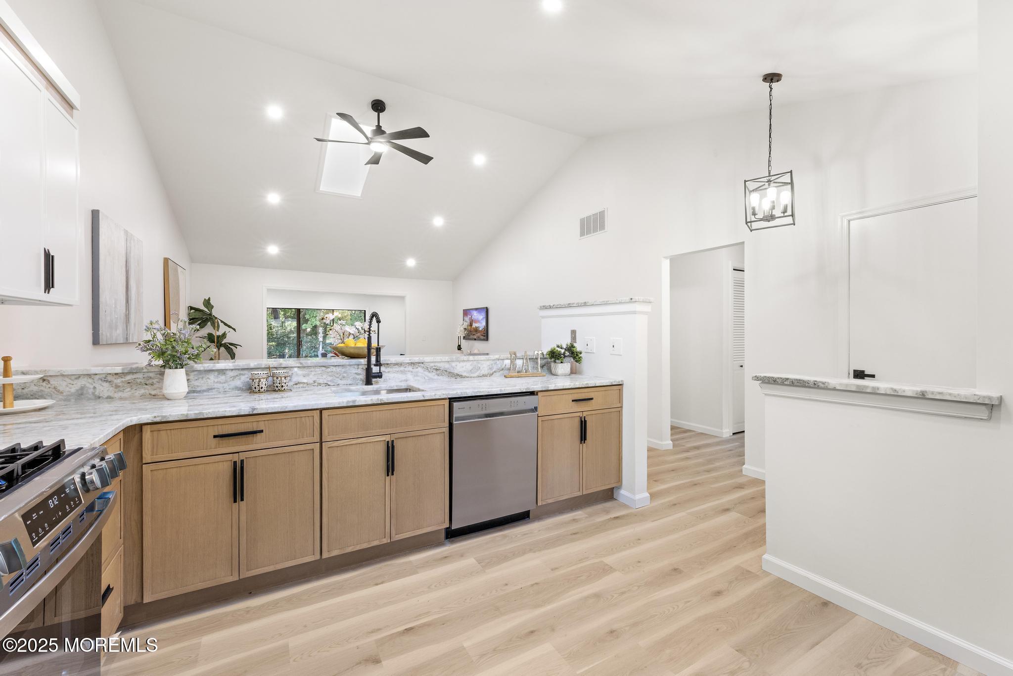 247 Jennings Road Manahawkin, NJ 08050 - Photo 9 of 35 a open kitchen with stainless steel appliances granite countertop a sink dishwasher and a refrigerator with wooden floor