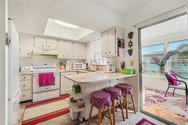 a kitchen with kitchen island granite countertop a sink and cabinets